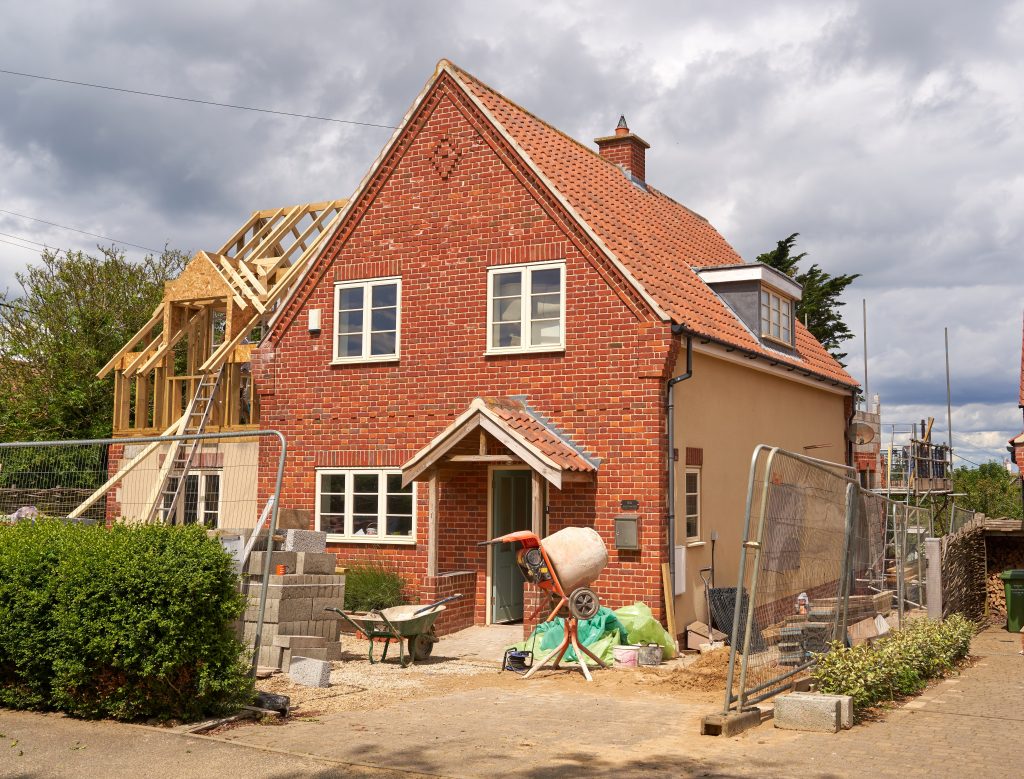 Modern second-story home addition with matching siding and updated roofline.